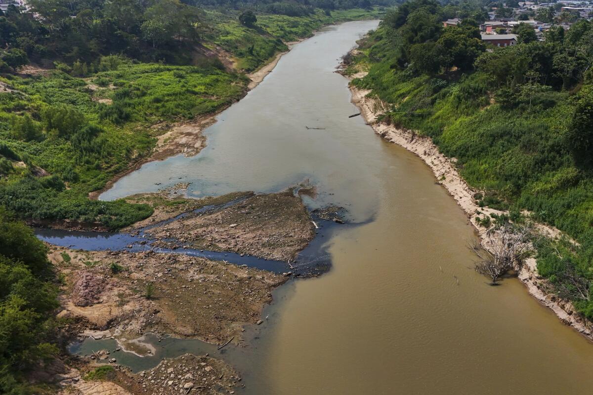 Aguas negras, izquierda, contaminan el río Acre, cerca del río Branco,