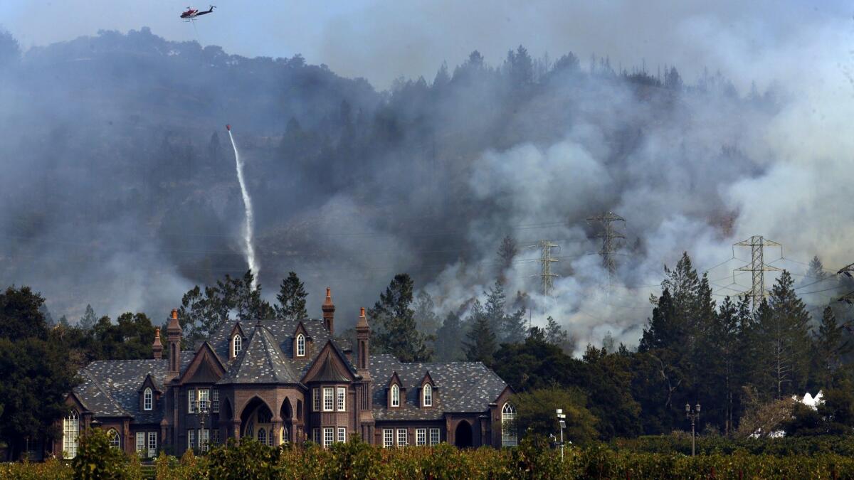A helicopter drops water to douse fire threatening the Ledson Winery in Sonoma County in October.