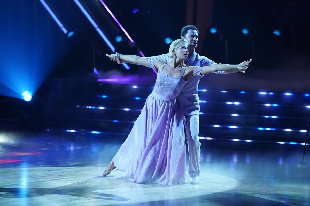 A man and a woman dancing onstage under blue lights