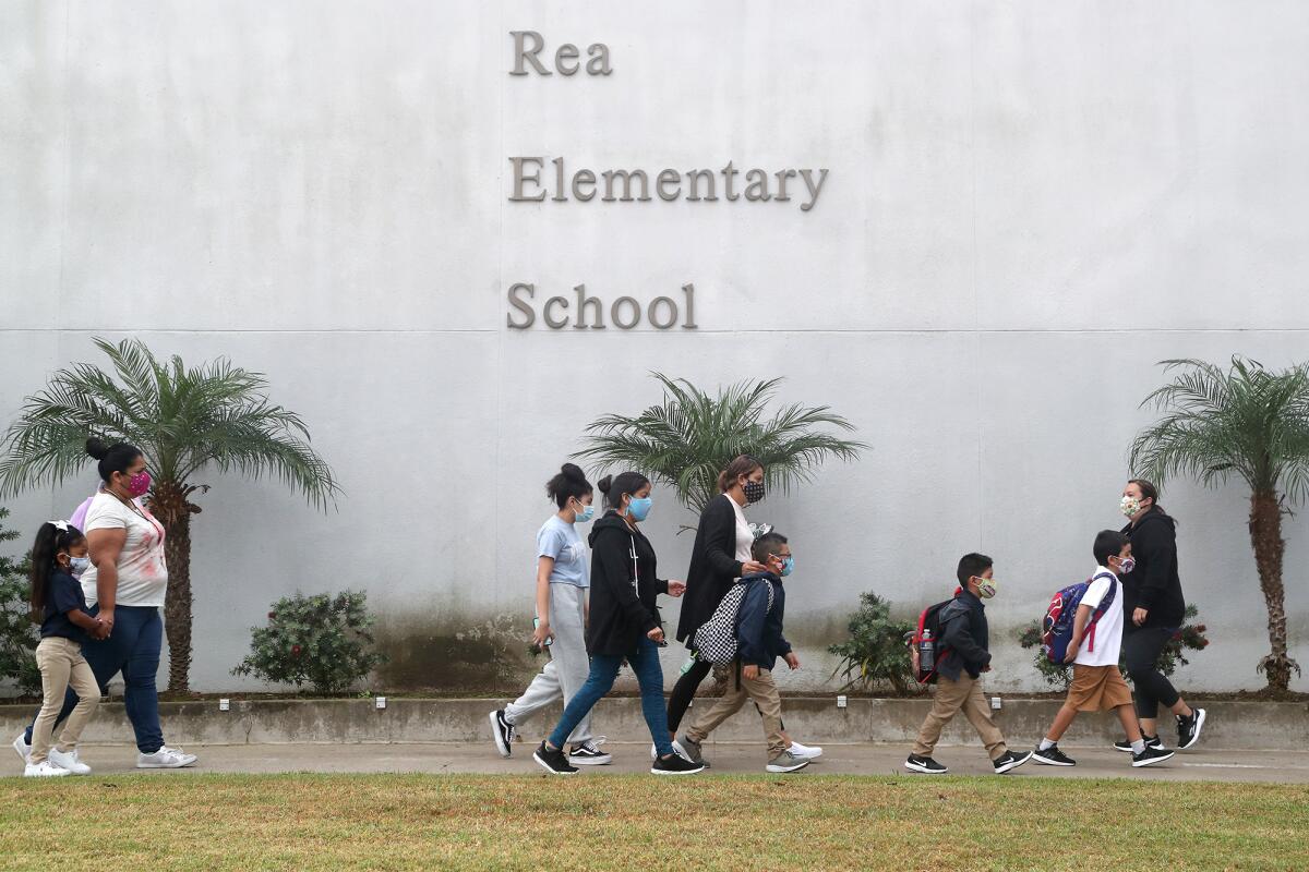 Students and parents walk to Rea Elementary School in Costa Mesa on the first day of school. 