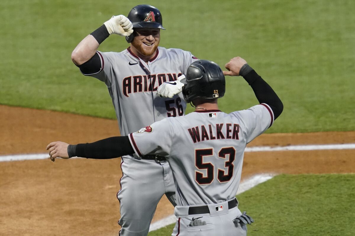 Arizona Diamondbacks' Kole Calhoun, left, celebrates a two-run home run with Christian Walker during the first inning of the team's baseball game against the Los Angeles Angels on Tuesday, Sept. 15, 2020, in Anaheim, Calif. (AP Photo/Ashley Landis)