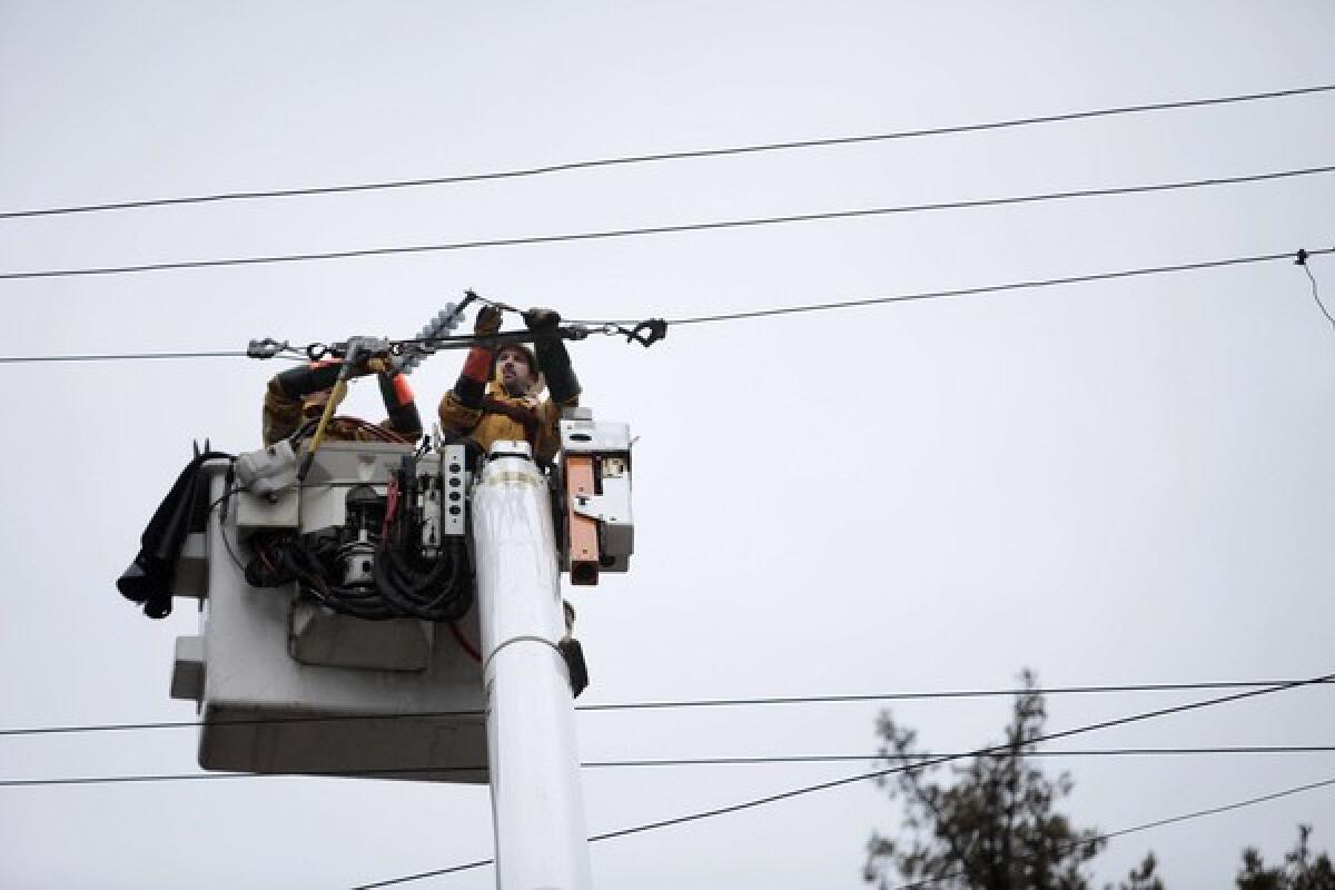 A PG&E crew works to restore power as a storm sweeps through Felton, Calif.