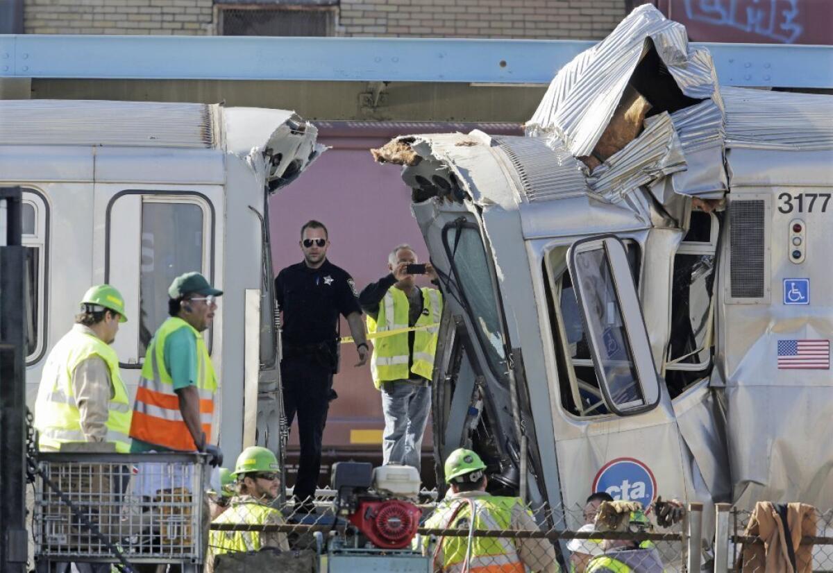 Authorities inspect the wreckage of two Chicago Transit Authority trains that crashed Monday, Sept. 30, 2013, in Forest Park, Ill. The crash happened when a westbound train stopped at the CTA Blue Line Harlem station and was struck by an eastbound train on the same track.