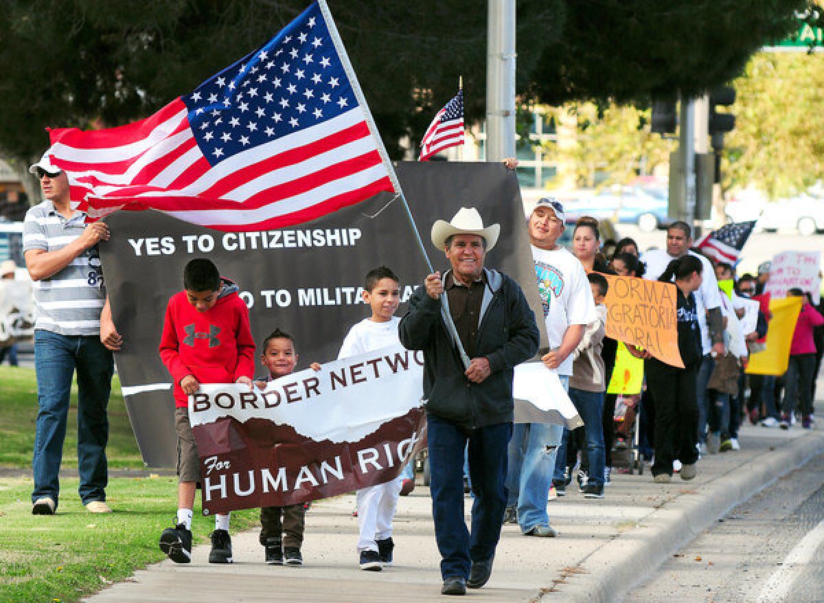 Jose Gonzalez of El Paso carries the American flag as he leads demonstrators to the office of Rep. Steve Pearce (R-N.M.) earlier this year.