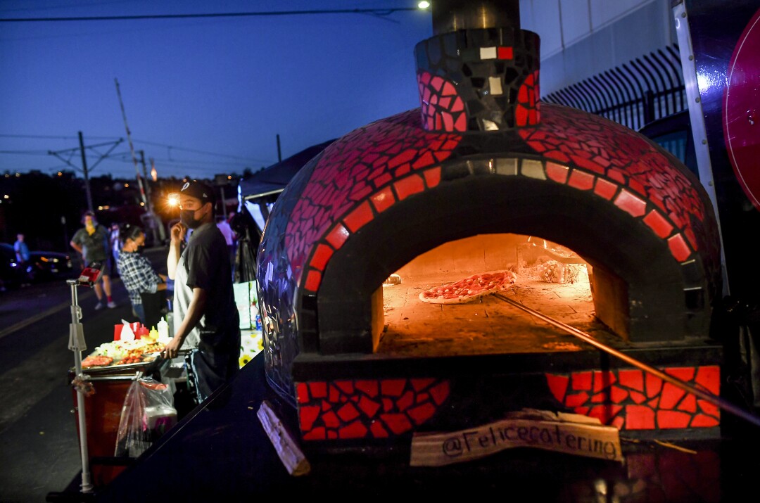 Pizzas going into the oven at Felice Catering during the Avenue 26 night market in Lincoln Heights.