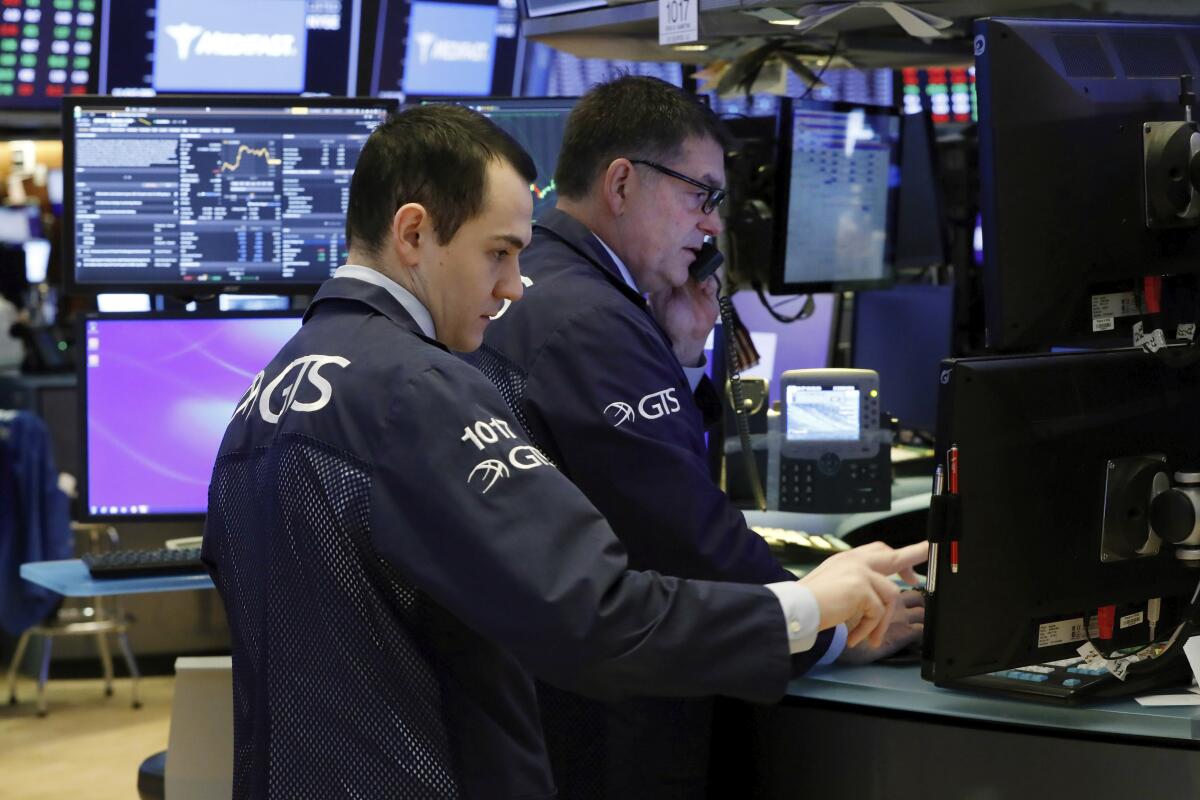 Two specialists prepare for the day's trading on the floor of the New York Stock Exchange on Monday.