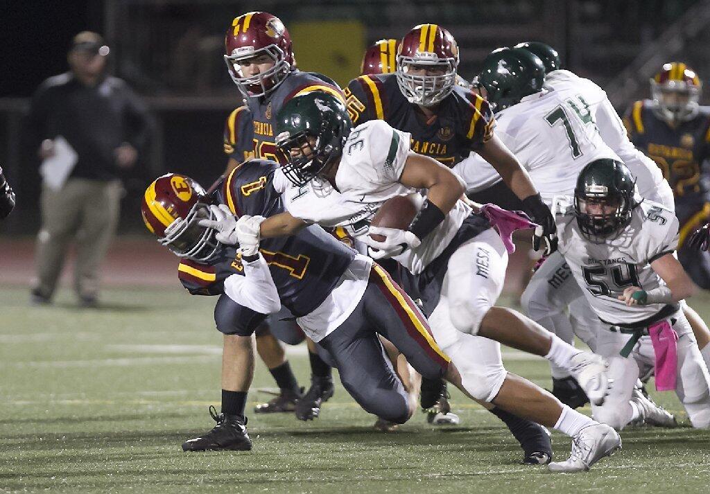 Costa Mesa High's Christopher Abac stiff-arms Estancia defender Hunter Mensinger, who brings him down anyway, during the Battle for the Bell at Estancia High on Friday.