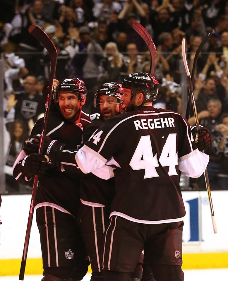 Kings forward Justin Williams, center, is congratulated by teammates Dwight King, left, and Robyn Regehr after scoring the go-ahead goal during the third period of the Kings' 4-1 win over the San Jose Sharks in Game 6 of the Western Conference quarterfinals at Staples Center.