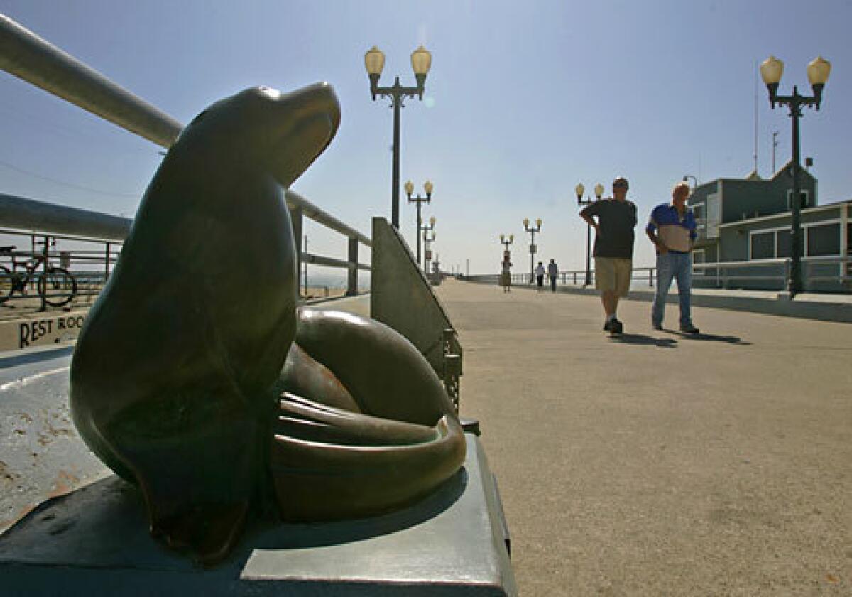 A bronze seal statue frolics on the Main Street pier in Seal Beach.