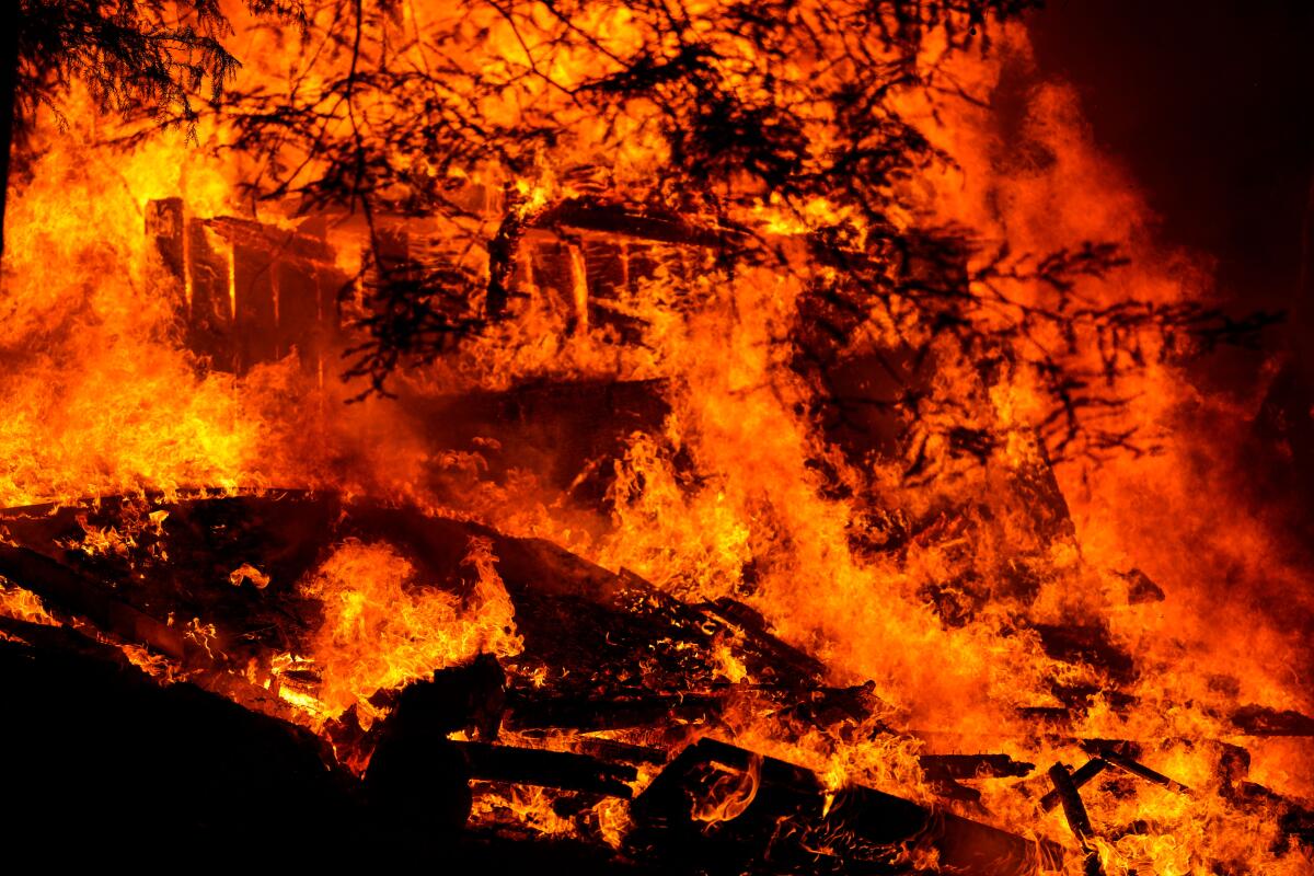 A house is engulfed in flames during the CZU Lightning Complex fires on Sunday