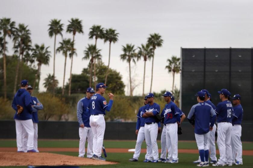 Los Angeles Dodgers bench coach Bob Geren (8) talks with a group of pitchers at the team's spring training baseball facility Wednesday, Feb. 14, 2018, in Glendale, Ariz. (AP Photo/Carlos Osorio)