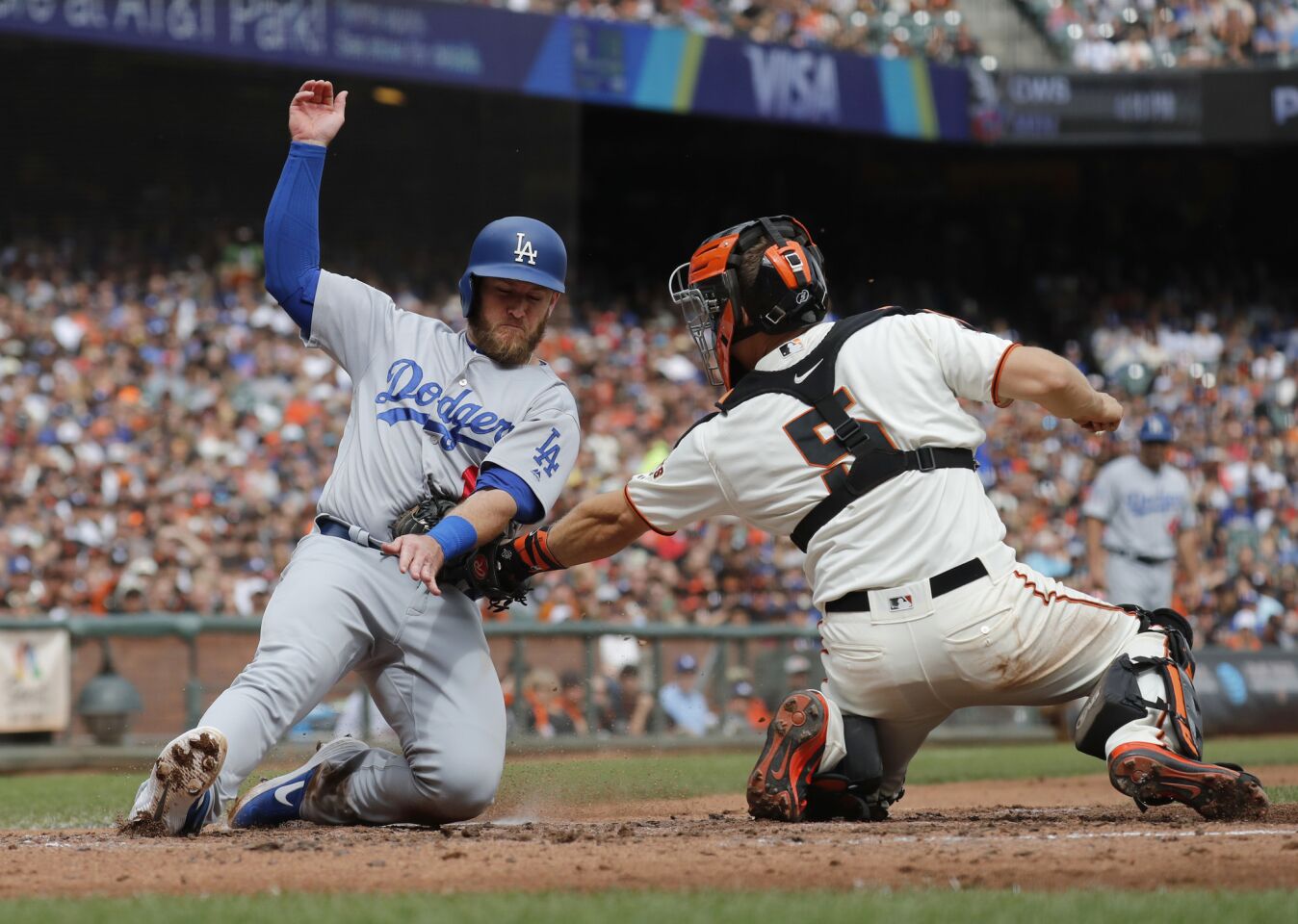 San Francisco Giants catcher Nick Hundley (5) tags out Los Angeles Dodgers' Max Muncy (13) at home during the third inning of a baseball game in San Francisco, Saturday, Sept. 29, 2018. (AP Photo/Jim Gensheimer)