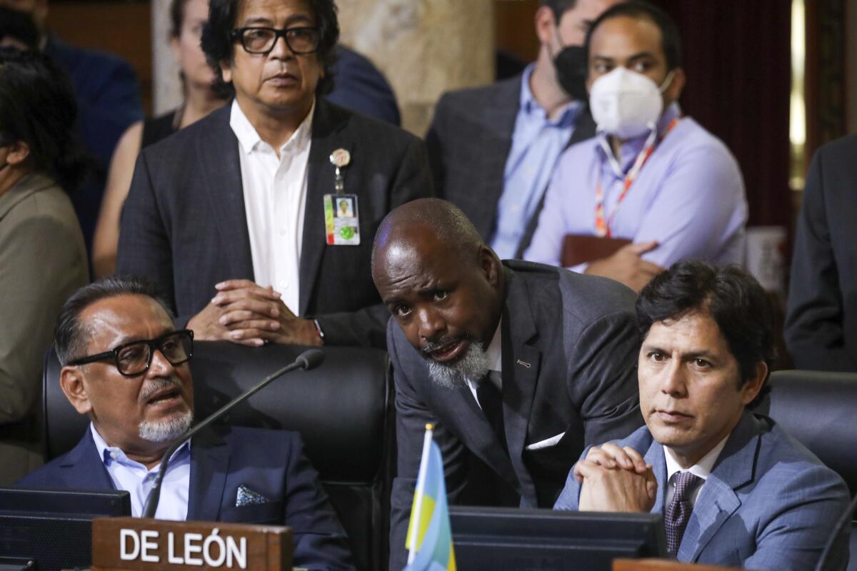 L.A. City Councilman Marqueece Harris-Dawson, center, talks to Councilmen Gil Cedillo and Kevin de León at a meeting.