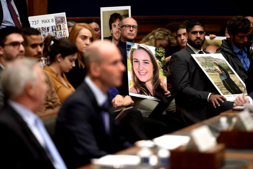 Family members of those who died aboard Ethiopian Airlines Flight 302 hold photographs of their loved ones as Dennis Muilenburg (R), President and CEO of the Boeing Company, and John Hamilton (L), Vice President and Chief Engineer of Boeing Commercial Airplanes, testify at a hearing in front of congressional lawmakers on Capitol Hill in Washington, DC on October 30, 2019. (Photo by Olivier Douliery / AFP) (Photo by OLIVIER DOULIERY/AFP via Getty Images) ** OUTS - ELSENT, FPG, CM - OUTS * NM, PH, VA if sourced by CT, LA or MoD **