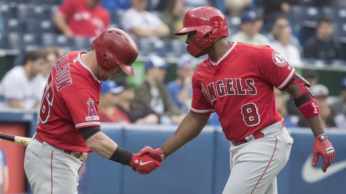 Angels left fielder Justin Upton, right, is congratulated by teammate Kole Calhoun after hitting a home run against the Toronto Blue Jays on Monday.