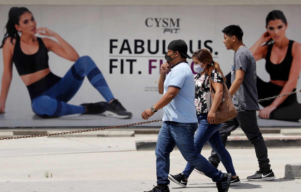 Pedestrians walk past a shuttered gym along Pacific Avenue in Huntington Park on April 29. Gov. Gavin Newsom said he expects to release guidelines in about to week that will allow gyms and fitness studios to reopen.