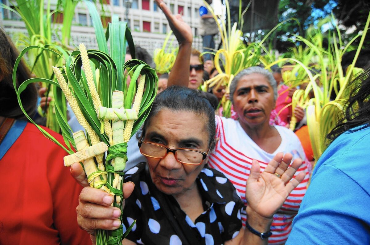 Pilgrims attend a Palm Sunday mass in Tegucigalpa, Honduras, on March 29. The nation's safety has improved, but it still has high levels of crime and violence, the U.S. State Department says.