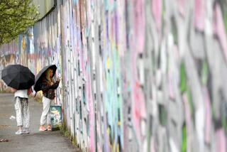 Tourists sign the “peace walls” that still separate some nationalist and unionist neighborhoods in west Belfast, Northern Ireland, Wednesday, April 5, 2023. It has been 25 years since the Good Friday Agreement largely ended a conflict in Northern Ireland that left 3,600 people dead. (AP Photo/Peter Morrison)