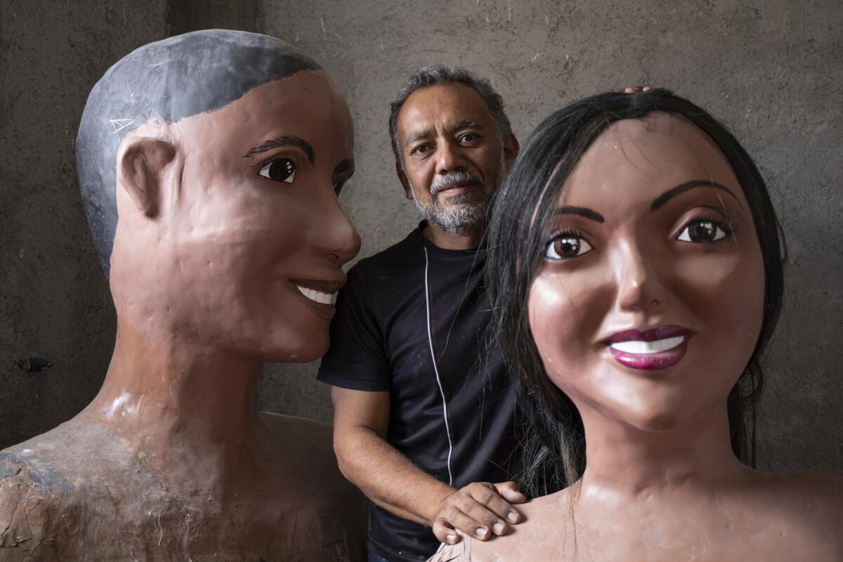 Tonatiuh Estrada, un artista oaxaqueño, posa con dos de sus obras en Oaxaca, 