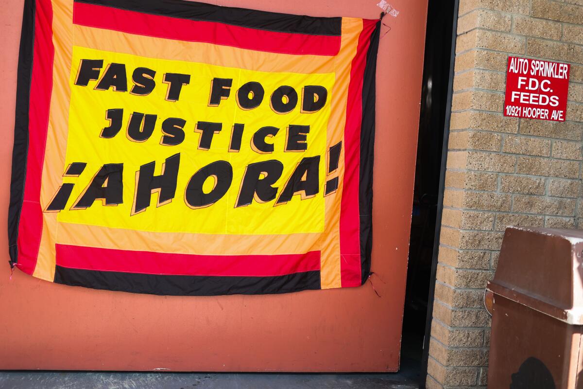 A sign is displayed saying "Fast Food Justice Ahora!"