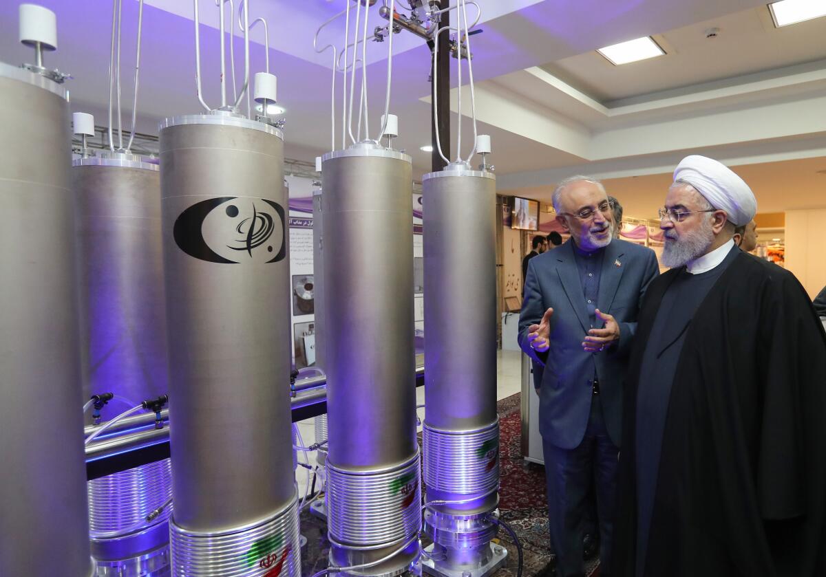 Iranian President Hassan Rouhani, right, listens to the head of Iran's nuclear technology organization, Ali Akbar Salehi.