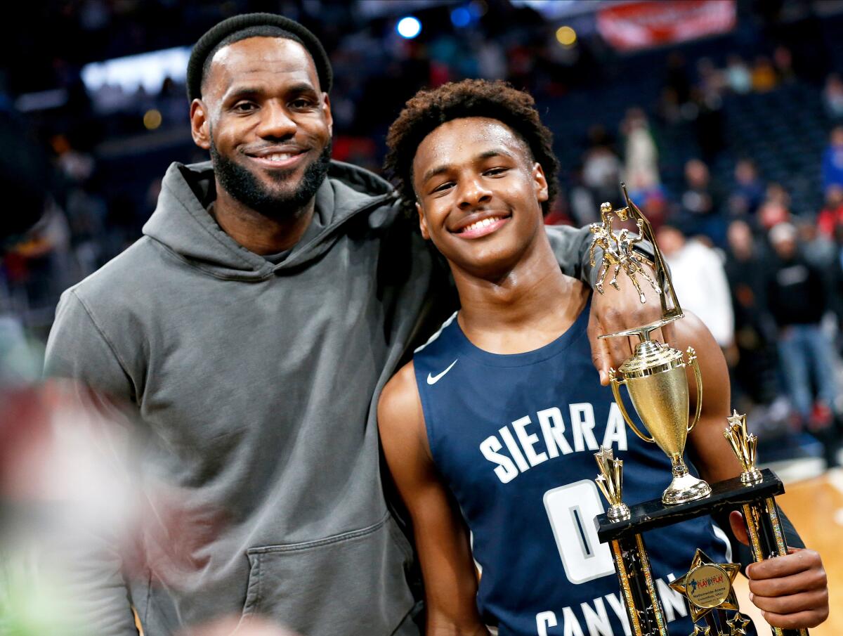 LeBron James, left, poses with his son Bronny after a Sierra Canyon High School basketball game in 2019.