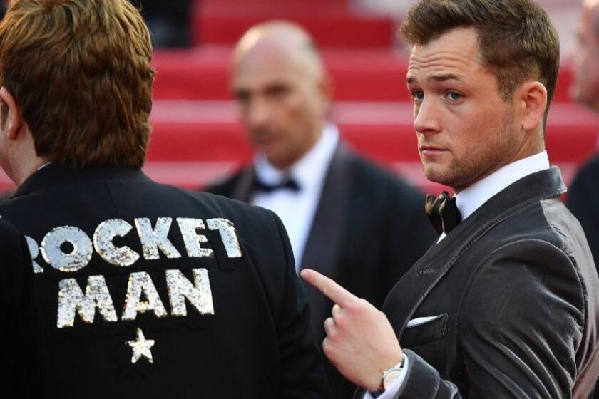 TOPSHOT - British actor Taron Egerton (R) shows the jacket of British singer-songwriter Elton John as they arrive for the screening of the film "Rocketman" at the 72nd edition of the Cannes Film Festival in Cannes, southern France, on May 16, 2019. (Photo by Alberto PIZZOLI / AFP)ALBERTO PIZZOLI/AFP/Getty Images ** OUTS - ELSENT, FPG, CM - OUTS * NM, PH, VA if sourced by CT, LA or MoD **