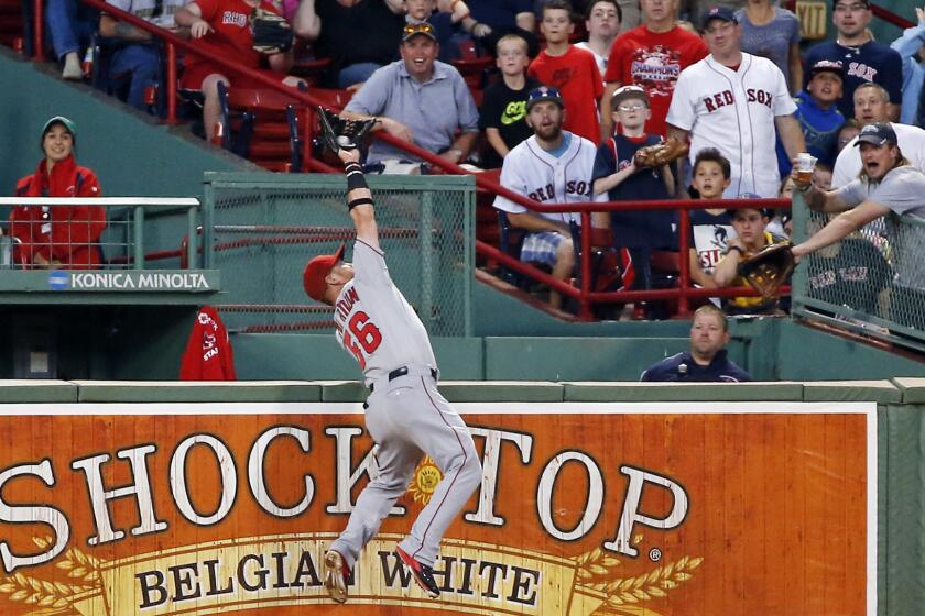 Angels right fielder Kole Calhoun makes a leaping catch on a ball hit by Boston's Brock Holt during the second inning of the Angels' 4-3 victory Tuesday.