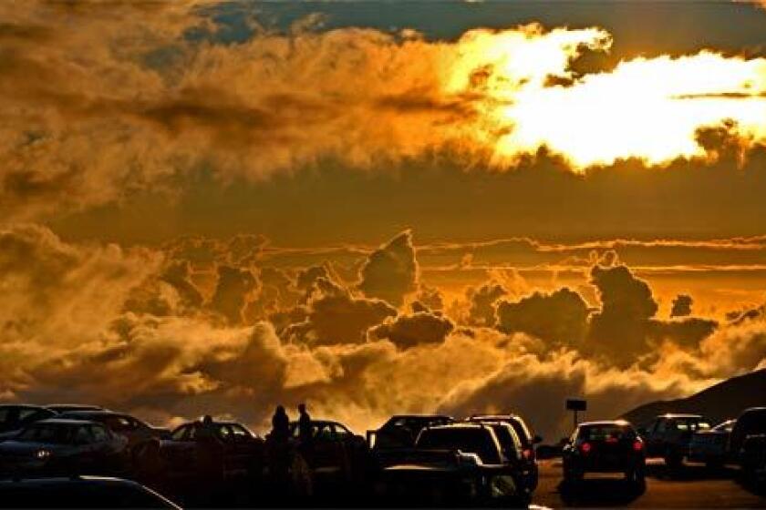 Visitors watch the sunset atop a volcano in Maui's Haleakala National Park.