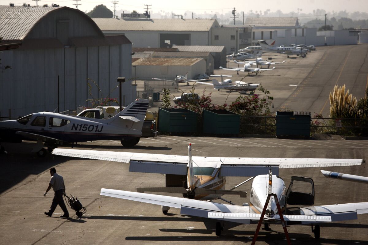 A mechanic walks away from parked planes at the Santa Monica Airport in this November 2011 photograph. In Santa Monica, voters faced competing ballot measures over the city's airport.