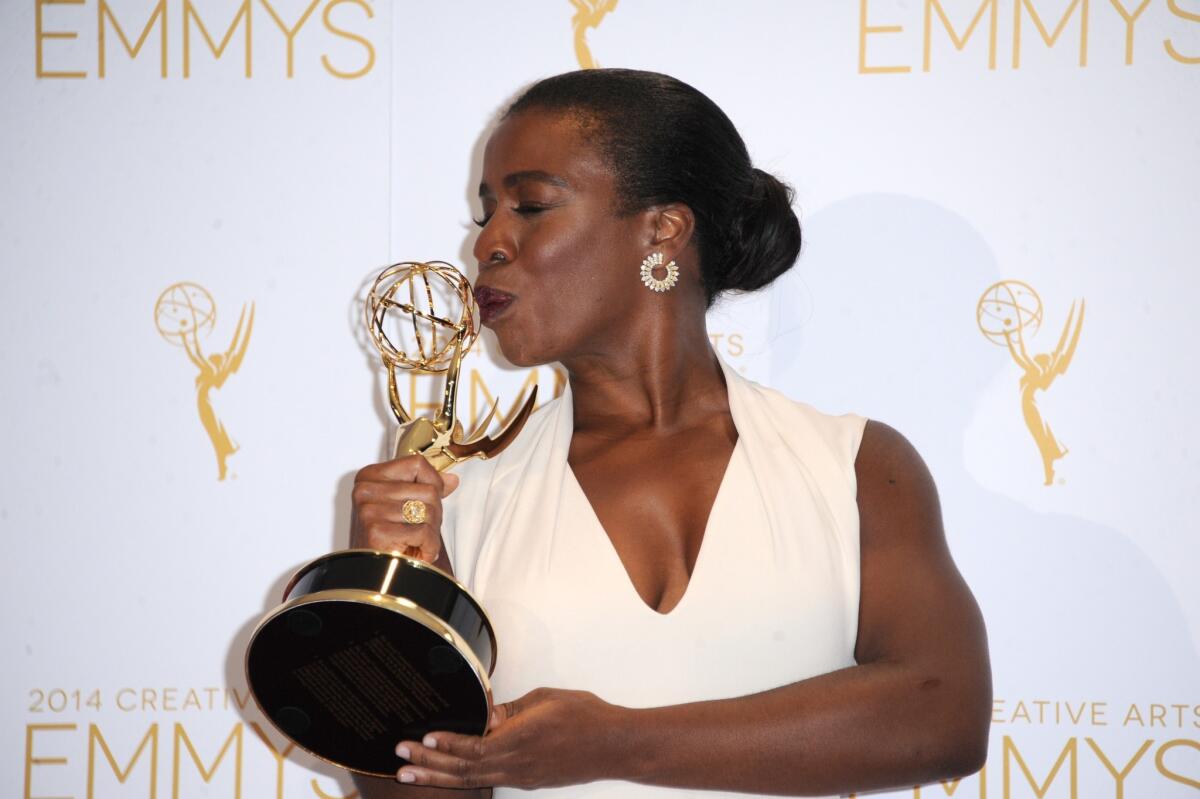 Uzo Aduba kisses her first Emmy in the press room at the Creative Arts Emmys on Saturday night in Los Angeles.