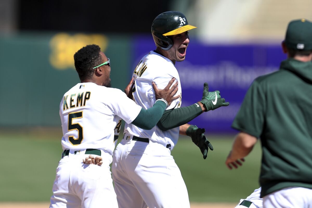 Oakland Athletics' Matt Olson, right, celebrates with teammate Tony Kemp, left, after driving in the winning run against the San Diego Padres during the 10th inning of a baseball game in Oakland, Calif., Wednesday, Aug. 4, 2021. (AP Photo/Jed Jacobsohn)