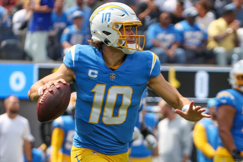 Chargers quarterback Justin Herbert rolls out to pass against the Las Vegas Raiders 