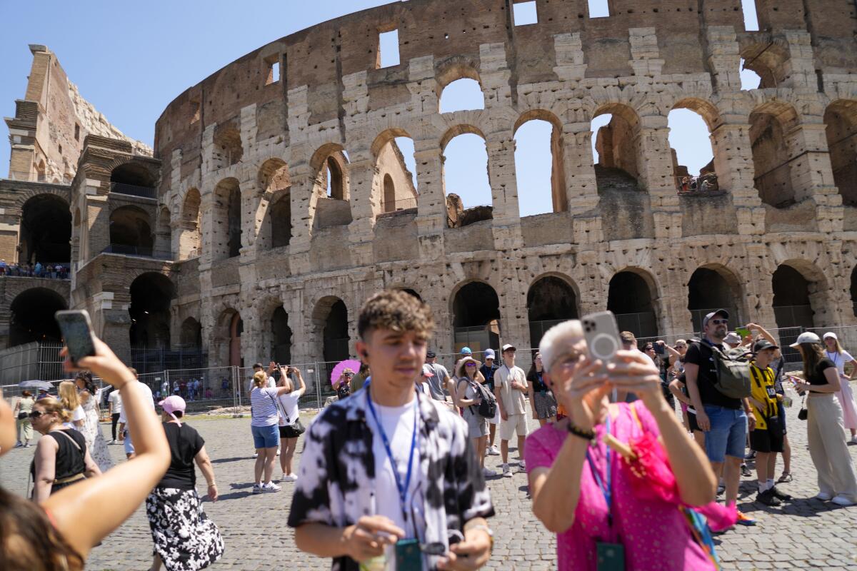 Visitors take photos of the Colosseum in Rome.