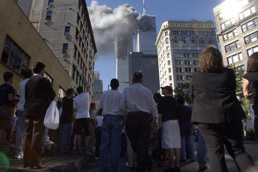 Pedestrians in lower Manhattan watch smoke billow from New York's World Trade Center on Tuesday, Sept. 11, 2001. (AP Photo/Amy Sancetta)