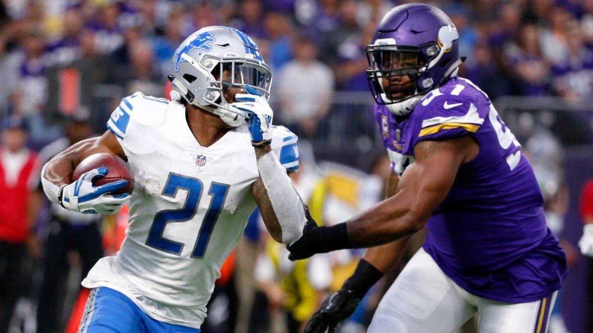 Detroit Lions running back Ameer Abdullah, left, runs from Minnesota Vikings defensive end Everson Griffen during the first half on Oct. 1.