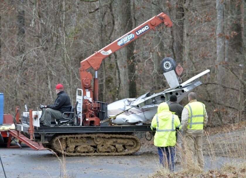 Salvage workers bring out part of a Piper PA-34's fuselage, wing, and landing gear from a crash site in Kuttawa, Ky. in January. The crash killed four family members and left a 7-year-old girl injured.