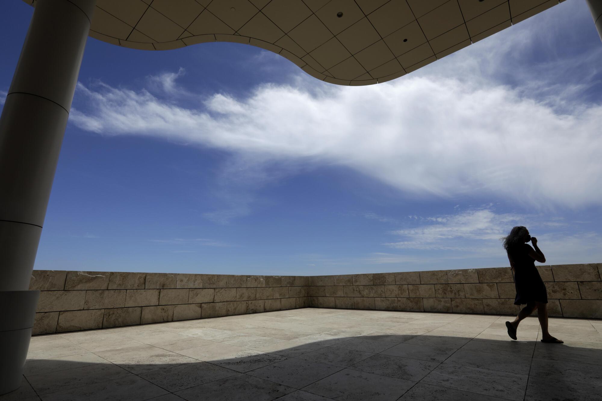 A visitor walks on a paved terrace at the Getty Center