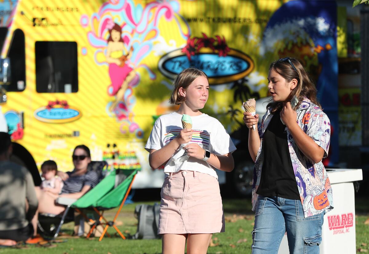 Teens enjoy ice cream during Costa Mesa's annual Concerts in the Park series at Fairview Park Tuesday.
