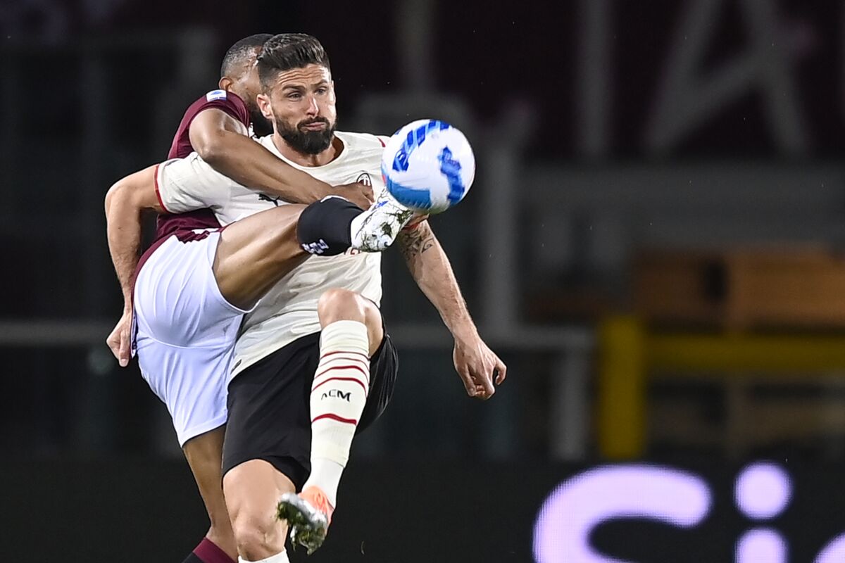 Torino's Bremer, left, and AC Milan's Olivier Giroud battle for the ball during the Serie A soccer match between Torino Fc and AC Milan at Olimpico Grande Torino stadium in Turin, Italy, Sunday April 10, 2022. (Fabio Ferrari/LaPresse via AP)