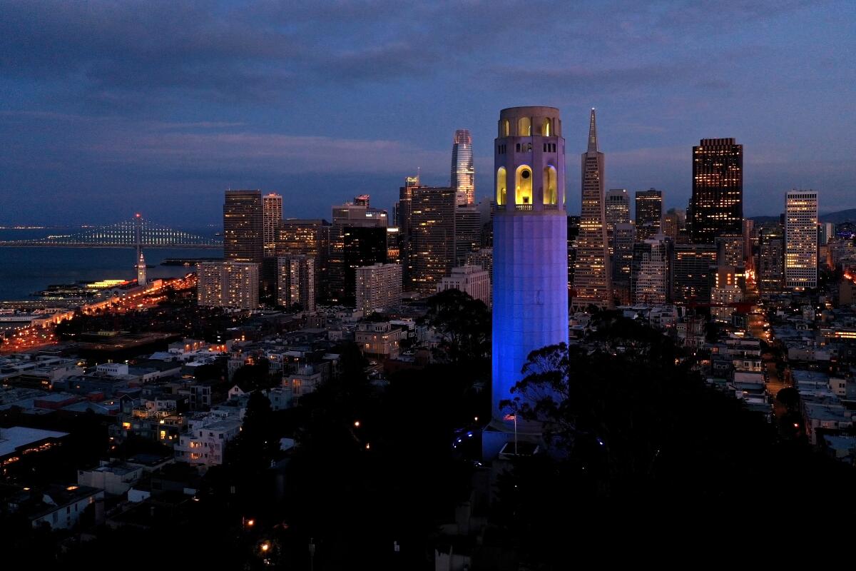Night view of Coit Tower lit up in blue
