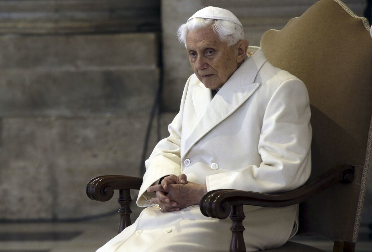 FILE - This Dec. 8, 2015 file photo shows Pope Emeritus Benedict XVI sitting in St. Peter's Basilica 