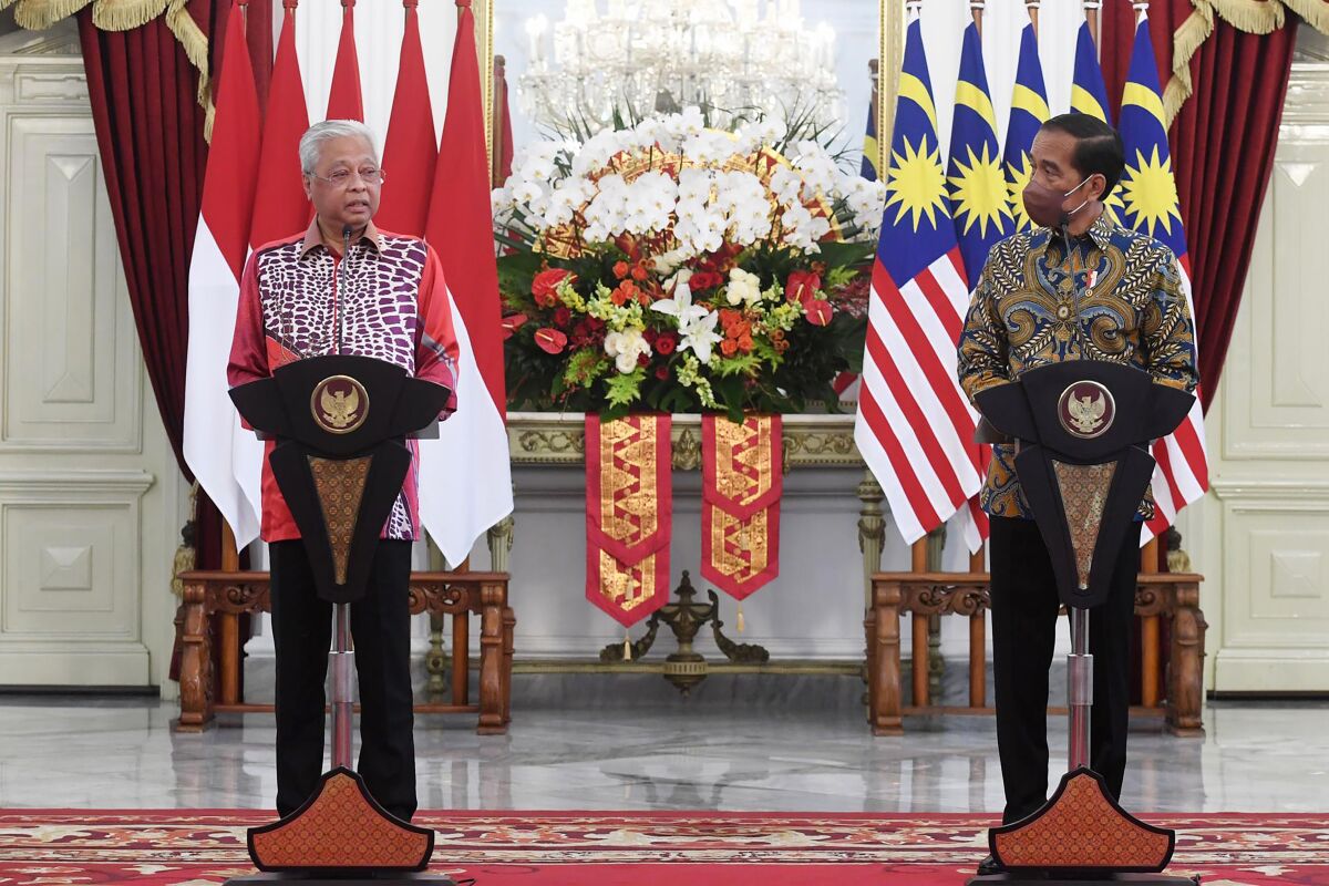 In this photo released by Indonesian Presidential Palace, Malaysian Prime Minister Ismail Sabri Yaakob, left, speaks as Indonesian President Joko Widodo looks on during a press conference following their meeting at Merdeka Palace in Jakarta, Indonesia, Friday, April 1, 2022. (Indonesian Presidential Palace via AP)