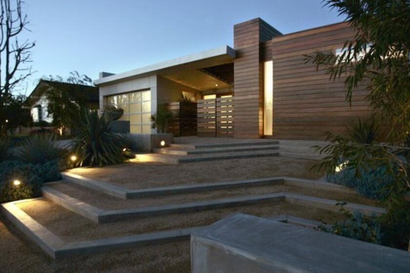Architect Annette Wiley turned her 1950s tract home in Corona del Mar into a contemporary residence remodeled with environmentally friendly materials and practices. The siding is ipe wood and cement board with recycled content. The steps leading to the entry are decomposed granite.