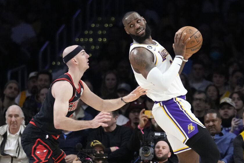 Los Angeles Lakers forward LeBron James, right, is defended by Chicago Bulls guard Alex Caruso during the first half of an NBA basketball game, Sunday, March 26, 2023, in Los Angeles. (AP Photo/Marcio Jose Sanchez)