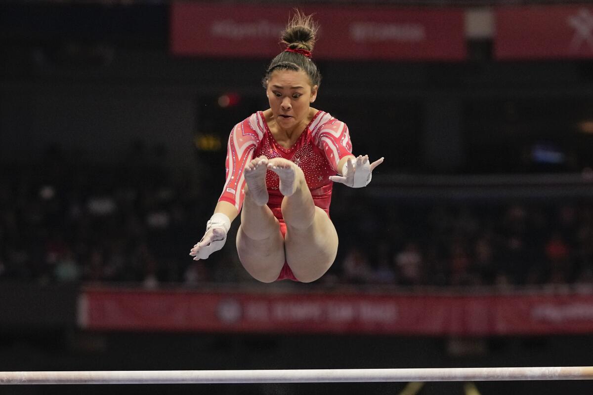A gymnast performs on the uneven bars.