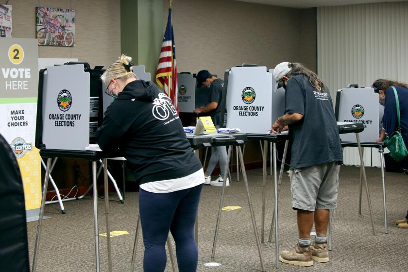 Voters cast their ballot at the Civic Center polling location, in Huntington Beach on Tuesday, Nov. 3, 2020.
