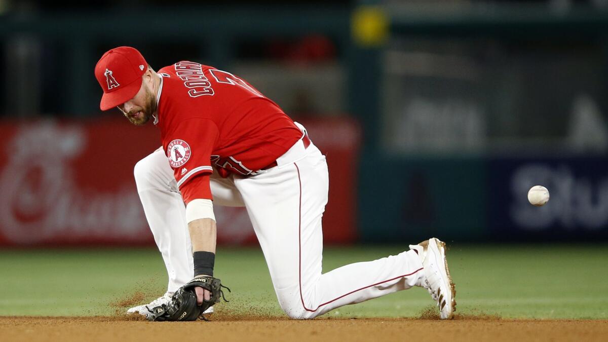 Angel's Zack Cozart is unable to handle a grounder hit by Texas Rangers' Shin-Soo Choo during the seventh inning at Angel Stadium on Friday.