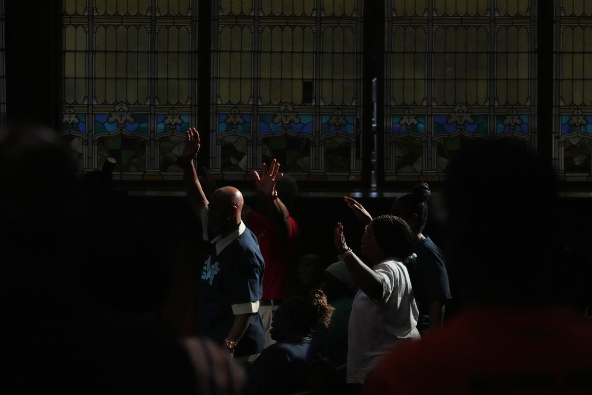 People praying during a vigil for mass shooting victims in Philadelphia