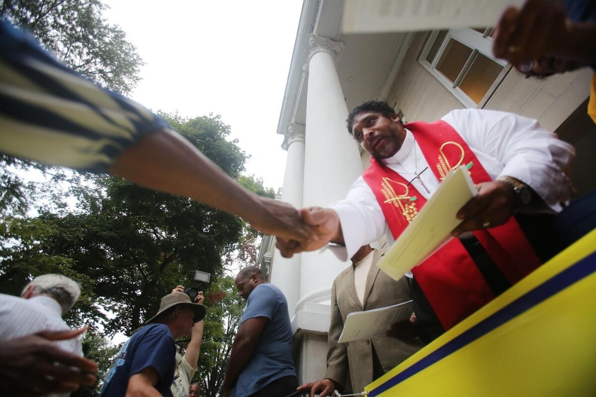 North Carolina NAACP's president, the Rev. Dr. William Barber, hands out voter registration papers at a Moral Monday protest in Shelby, N.C., on Sept. 8, 2014.